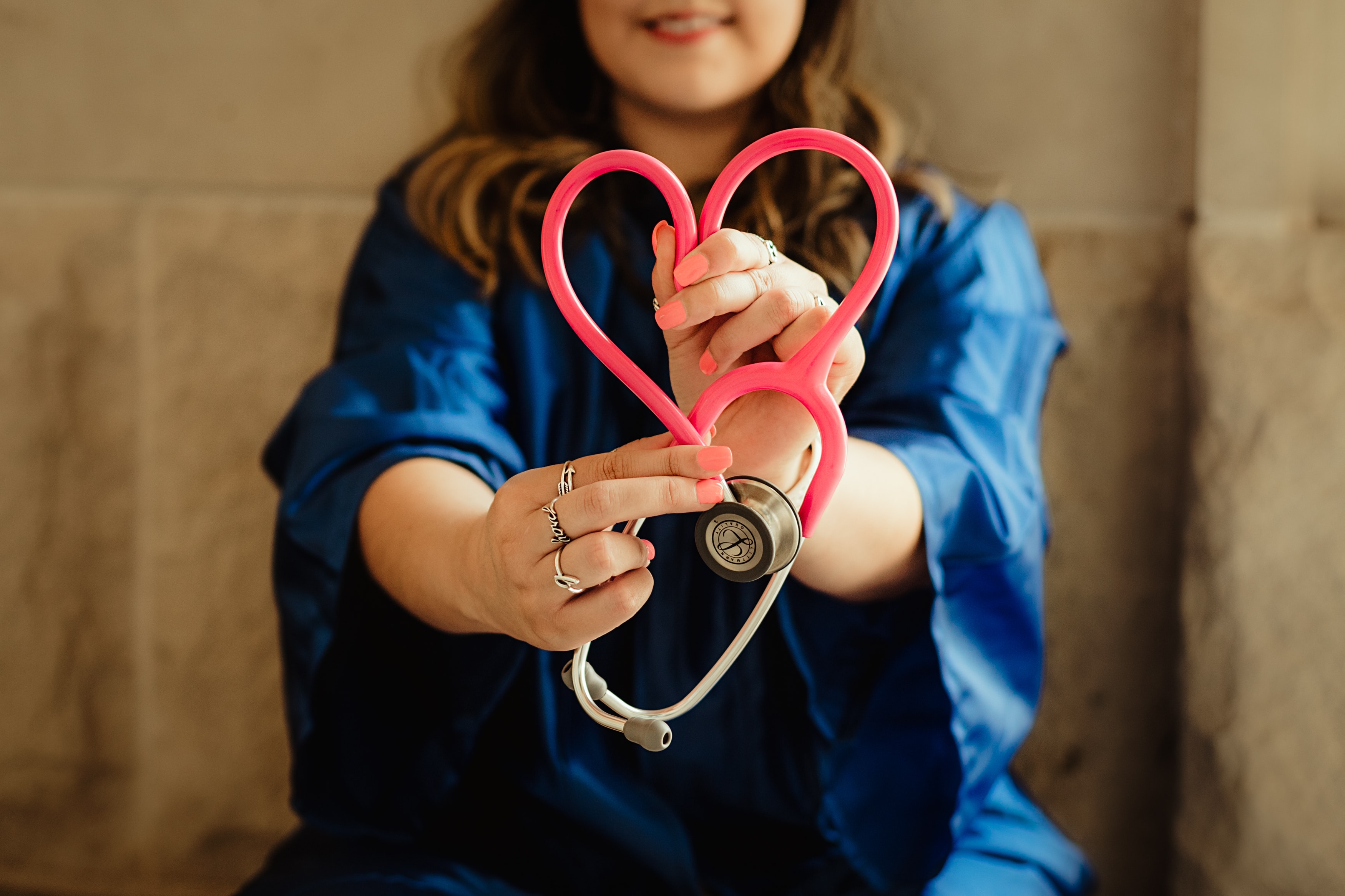 Ärztin hält ein Stetoskop in den Händen, das zu einem Herz geformt ist.