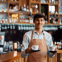 Kellner trägt zwei Kaffee und lächelt in die Kamera - Dienstplan Gastronomie 
