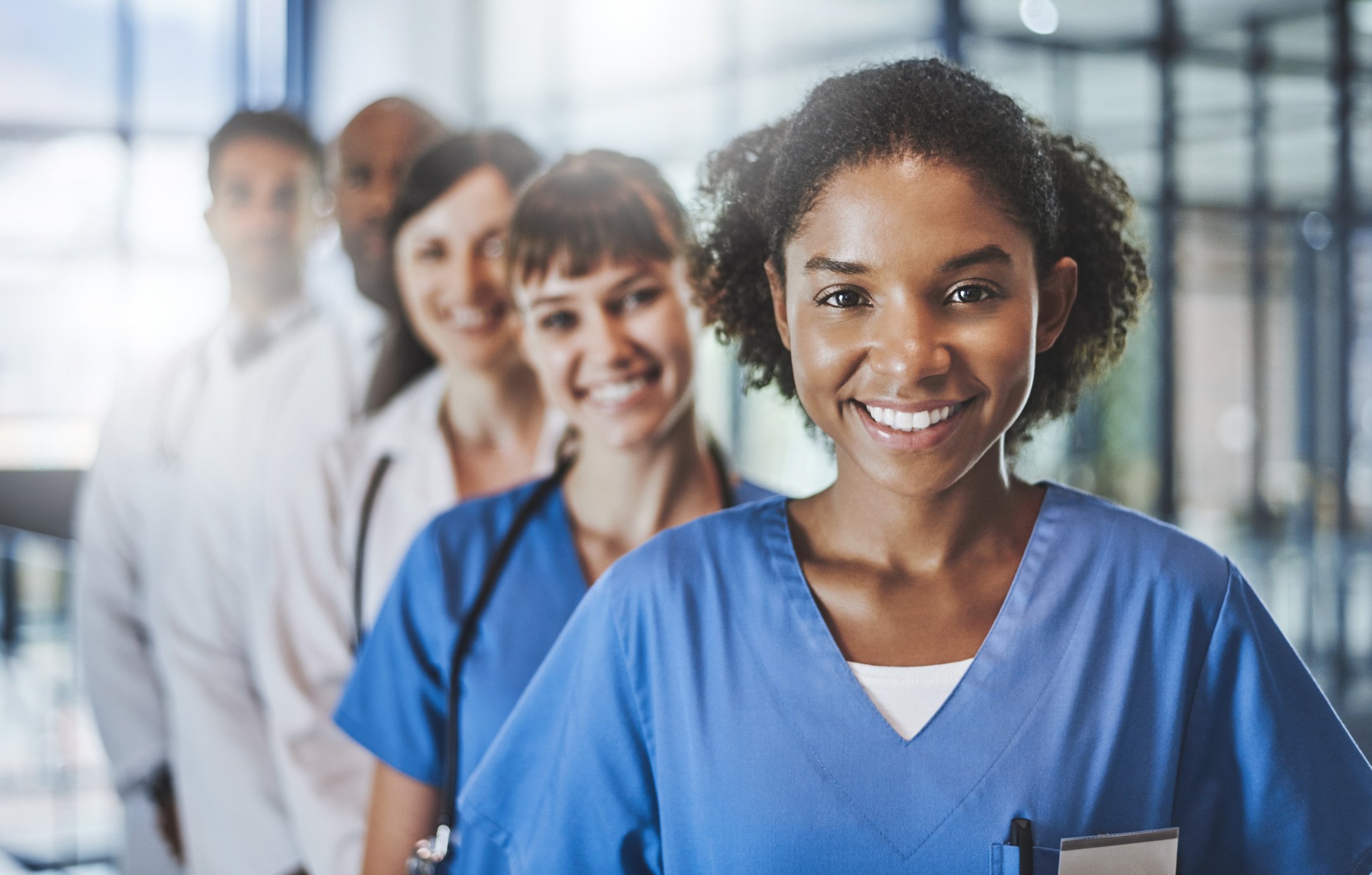 Ärzte-Team in Kitteln lächelt in die Kamera