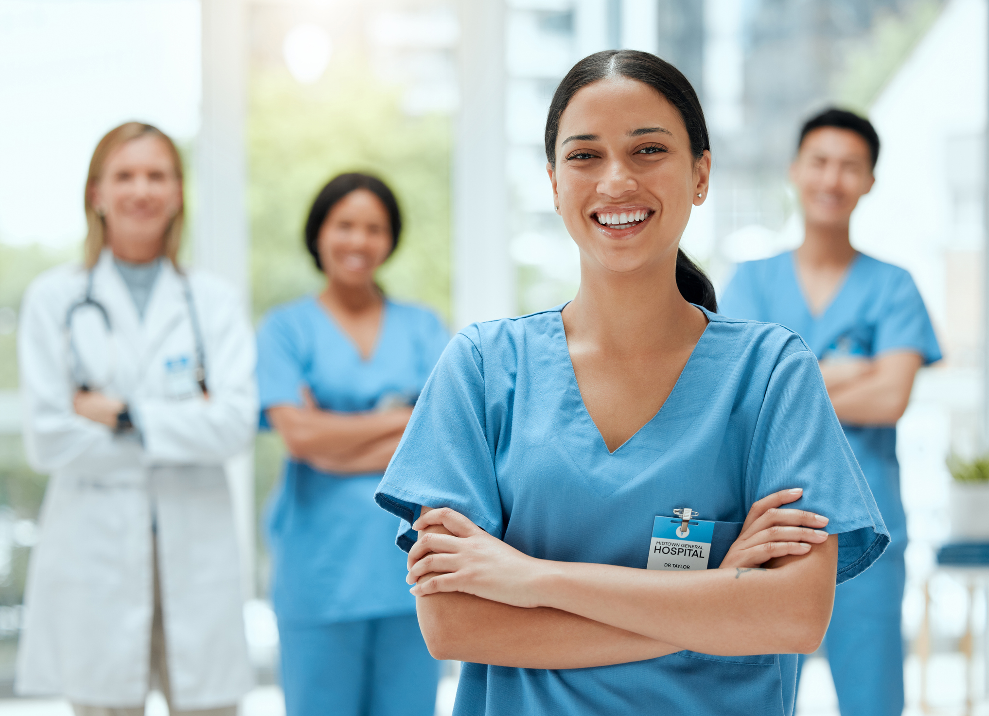 Glückliche Krankenschwester steht vor ihrem Team